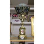 A gilded spelter cherub table lamp with Tiffany style dragonfly leaded glass shade, COLLECT ONLY.