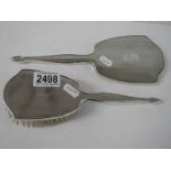 A silver backed hand mirror and a silver backed hair brush.