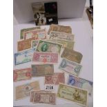 A collection of old bank notes and a D-Day 60th anniversary coin.