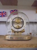 A Junghans magnetic balance wheel clock, small chip in glass dome and will need new batteries.