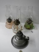 Three glass hand oil lamps and a metal example.