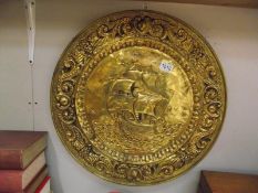 A large pressed brass wall plaque depicting sailing ship diameter 55cm COLLECT ONLY