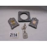Three small silver photo frames and a silver pendant.