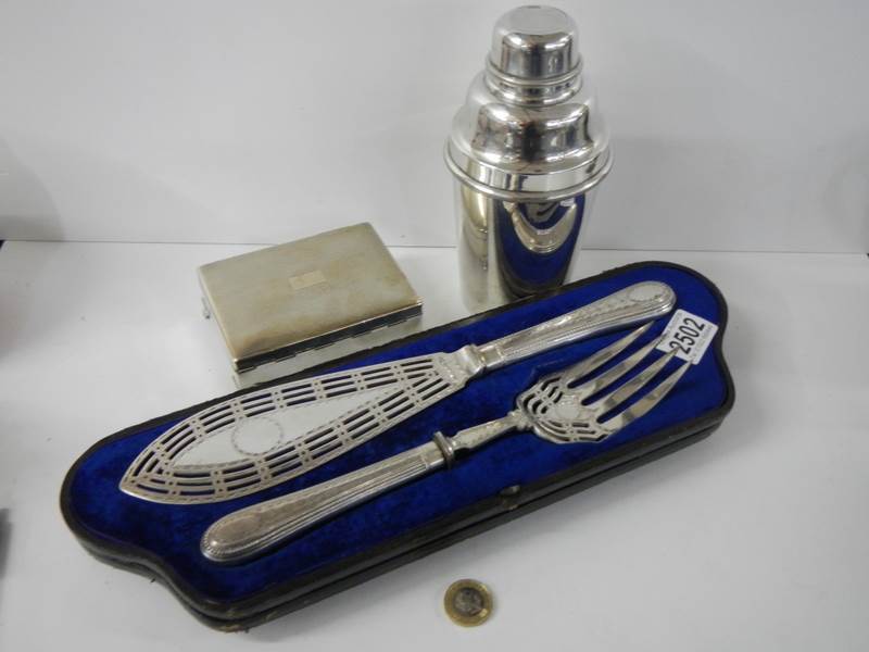 A superb quality pair of silver plate fish servers, a cocktail shaker and a cigarette box.