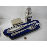 A superb quality pair of silver plate fish servers, a cocktail shaker and a cigarette box.
