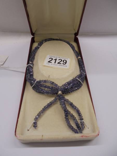 A tanzanite natural stone four strand necklace with silver tassle.