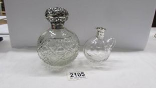 A cut glass scent bottle with silver top and a glass jug with silver spout.