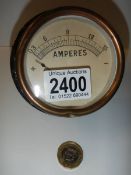 A bulkhead mounted dial gauge measuring amperes.