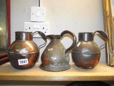 A Georgian copper quart measure jug and 2 Jersey? copper jugs