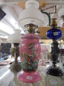 A Victorian overlaid pink glass oil lamp enamel painted with birds. COLLECT ONLY.