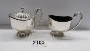 A pair of good quality hall marked silver salt and mustard pots with blue glass liners.