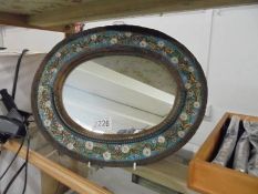 A small oval floral framed mirror.