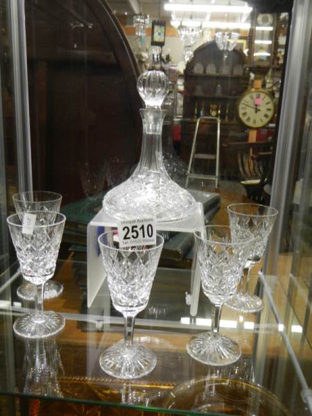 A small crystal ship's decanter and five glasses.