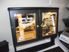 A 2 door wall mounted cabinet with 'jewellers and prescription opticians' advertising mirror doors