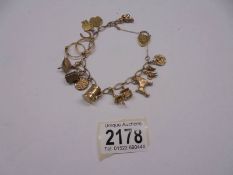 A 9ct gold bracelet with fourteen charms. 25.3 grams.