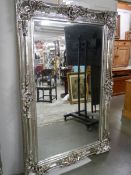 A large bevel edged mirror in silver gilded double swept frame, 125 x 185 cm. COLLECT ONLY.