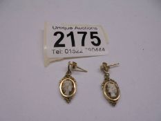 A pair of gold earrings set cameo's. 1.9 grams.