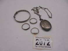 A silver locket on a silver chain, a silver child's bangle and three silver rings, 22 grams.