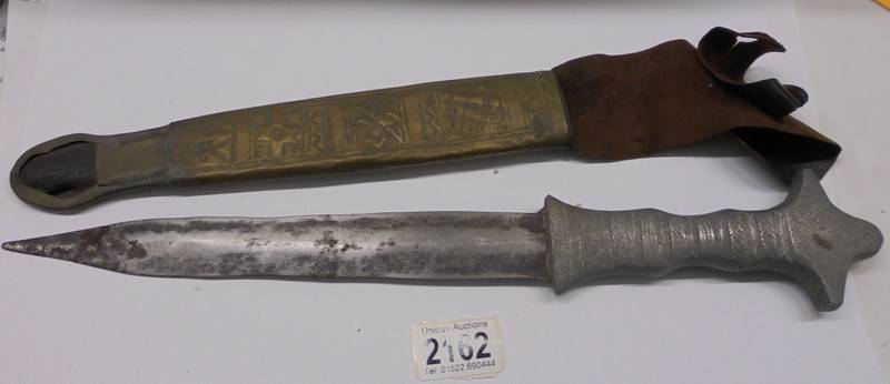 An old dagger with brass scabbard.