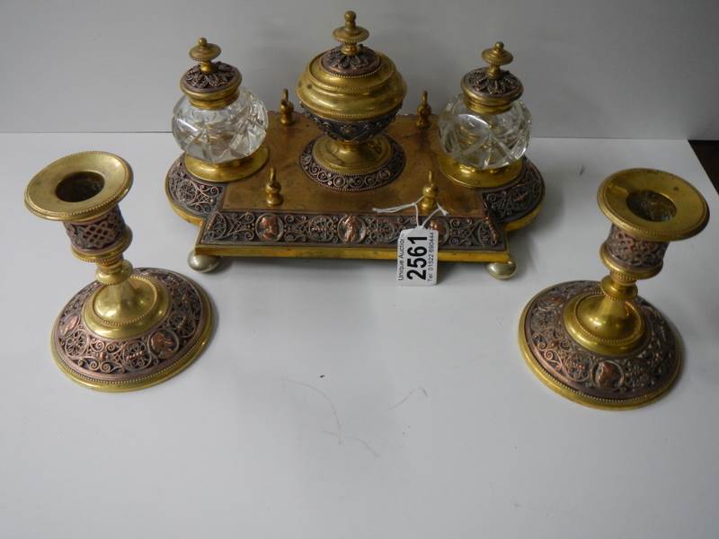 A late Victorian gilt bronze desk stand with matching inkwells and candlesticks.