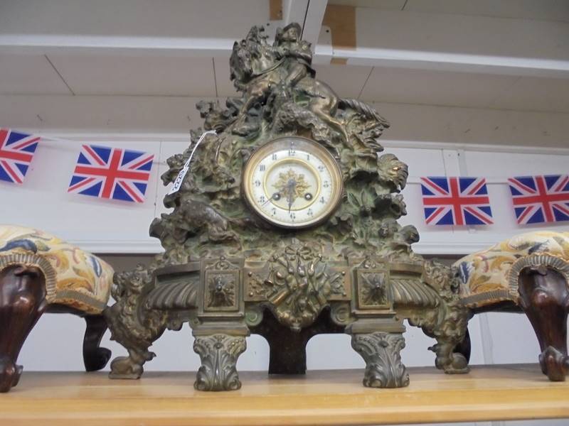 A Victorian cast iron 8 day clock with bronzed finish featuring horse, rider and gun dogs,
