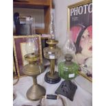 A brass oil lamp and two other oil lamps with glass fonts, COLLECT ONLY.