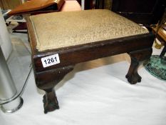 A 1930's oak footstool on ball and claw feet 37cm x 29cm x height 22cm COLLECT ONLY