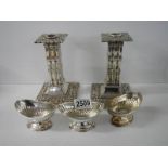 A pair of silver plate candlesticks and three silver plate salts.