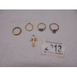Four 9ct gold rings and a 9ct gold cross, 7.3 grams.