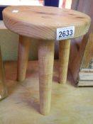 A three leg pine stool.