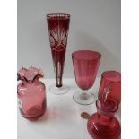 Five pieces of cranberry glass including vases, jugs etc.,