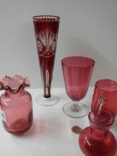Five pieces of cranberry glass including vases, jugs etc.,