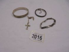 A silver bangle, a silver child's bangle, a silver bracelet and a silver cross on chain.