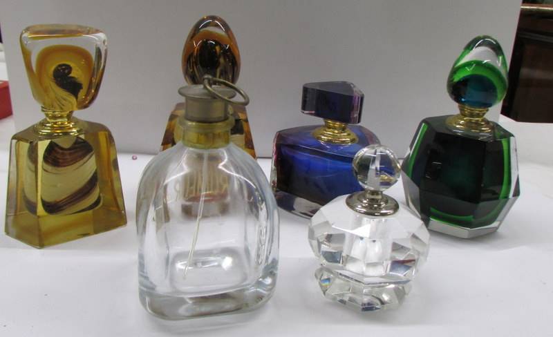 Four coloured perfume bottles and two clear glass bottles.
