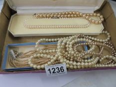 A cased string of Lotus pearls and four other pearl/faux pearl necklaces.