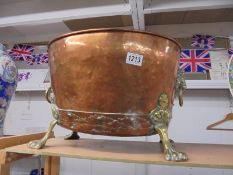 A brass and copper cauldron with lion head handles and lion paw feet. COLLECT ONLY.