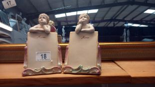 A pair of continental bisque winged cherub menu holders