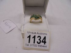 A 9ct gold ring set green stones, size S, 5.5 grams.