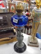 A Victorian oil lamp on spelter base and column with blue glass font. COLLECT ONLY.