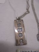 A silver ingot on a silver chain, 36.5 cm.