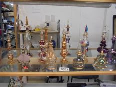 Fourteen coloured glass perfume bottles.