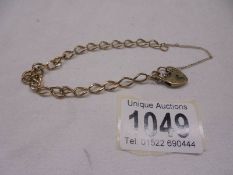 A 9ct gold wrist chain with padlock and safety chain. 7.6 grams.