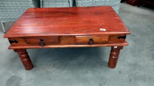 A dark wood stained rustic coffee table with iron fittings and 2 drawers