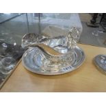 A silver plate gravy boat on tray.