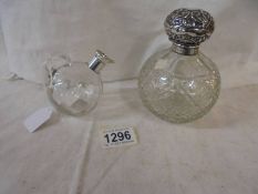 A silver topped cut glass scent bottle and a small glass oil/vinegar jug with silver spout.