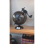 A black world globe with metal plane