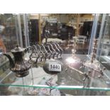 A silver plate toast rack, candlesticks, coffee pots, knife rests and snuff bottle.
