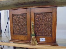 An oak smokers cabinet with carved doors.
