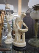 An Angel candlestick and a Grecian style figure.