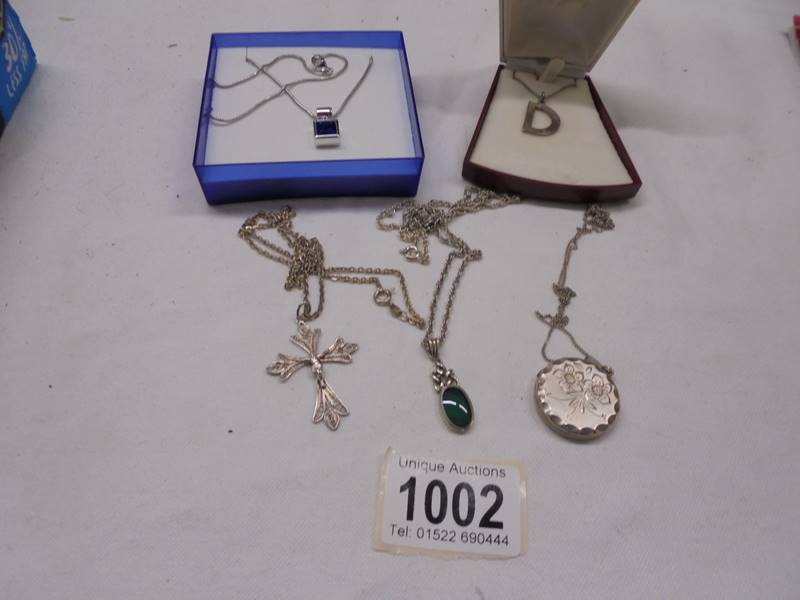 Three silver pendants, a silver locket and a silver (800) crucifix.